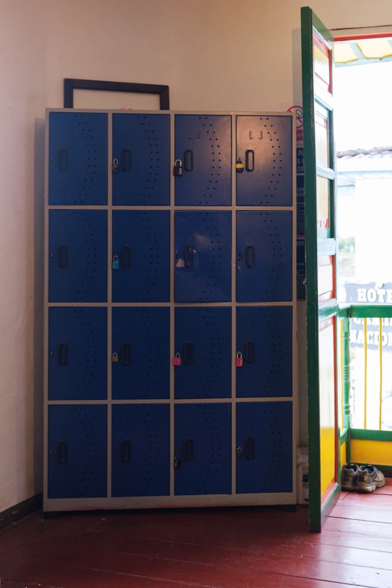 A blue metal locker unit beside an open balcony door in the large dorm